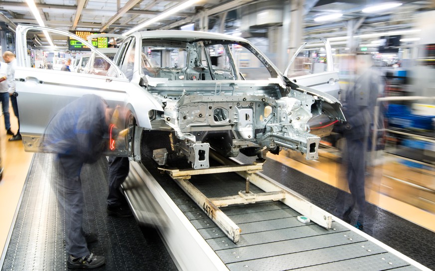 ARCHIV --- Mitarbeiter montieren am 1. Maerz 2019 Kotfluegel an einen Volkswagen Golf VII im Karosseriebau im VW Werk in Wolfsburg, Deutschland. (Aufnahme mit langer Verschlusszeit). (zu dpa &quot;Vol ...