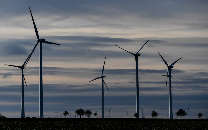 epa06387248 A cloudy sky is pictured above a wind turbines on a field near Halle, Eastern Germany, 13 December 2017. Meteorologist predict the cloudy weather with temperatures around 04 degrees Celsiu ...