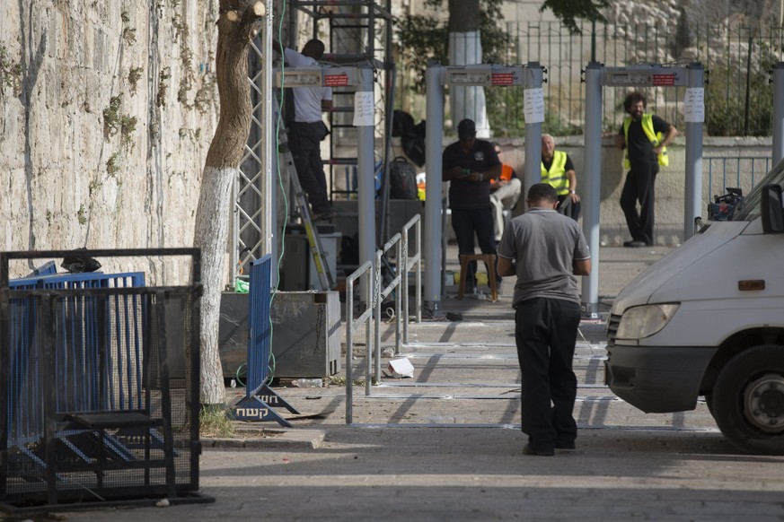 epa06107141 Israeli employees install a barrier next to the metal detectors outside Lions' Gate, the main the entrance to the Al-Aqsa compound, as part of the security measures taken by the Israeli po ...