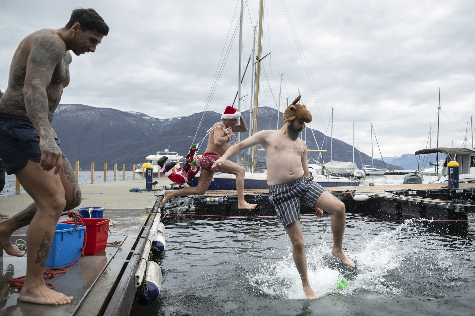 Teilnehmer anlaesslich des Befana-Schwimmens in Brissago, am Samstag, 6. Januar 2024. Beim traditionellen Dreikoenigs-Schwimmen &quot;Nodada de la Befana&quot; wird der Lago Maggiore im Hafen von Bris ...