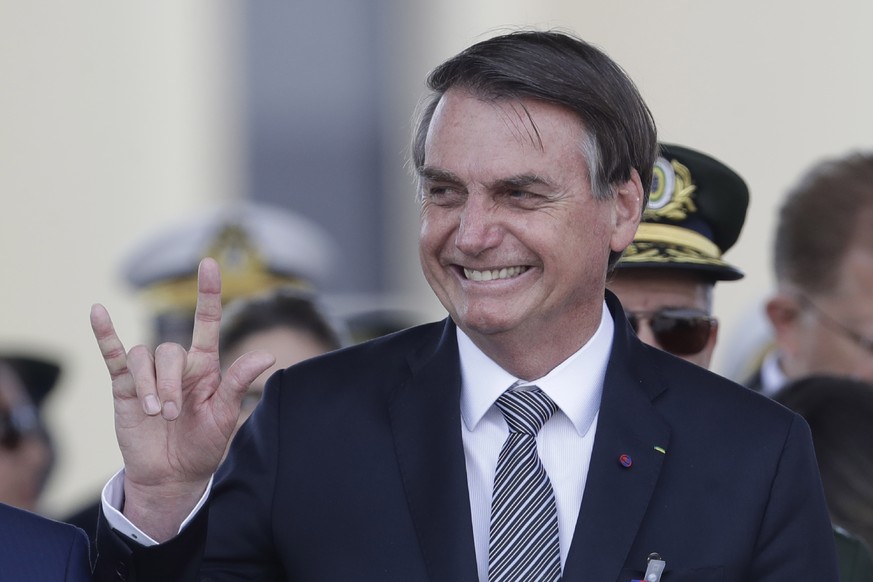 Brazils President Jair Bolsonaro makes a signal with his hand during a military ceremony for the Day of the Soldier, at Army Headquarters in Brasilia, Brazil, Friday, Aug. 23, 2019. Brazilian Presiden ...