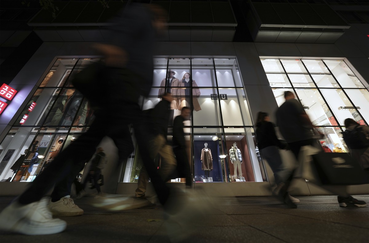 People walk past a store at the famous shopping road Kurfuerstendamm, better known as 'Kudamm', in Berlin, Germany, Tuesday, Oct. 11, 2022. (AP Photo/Michael Sohn)