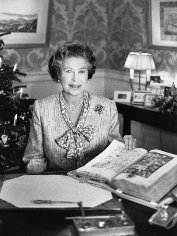 1988 Queen Elizabeth II during her Christmas Day speech to the Commonwealth, looking at a picture of the Nativity in the Sobieski "Book of Hours" from the Royal Library at Windsor. (Photo by ...