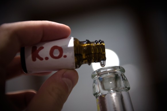 ARCHIV - 02.12.2015, Bayern, Aufseß: ILLUSTRATION - Ein Mann füllt in der gestellten Szene mehrere «K.-O. Tropfen» in eine Bierflasche. (zu dpa: «Bundesgerichtshof: K.o-Tropfen kein "gefährliches ...