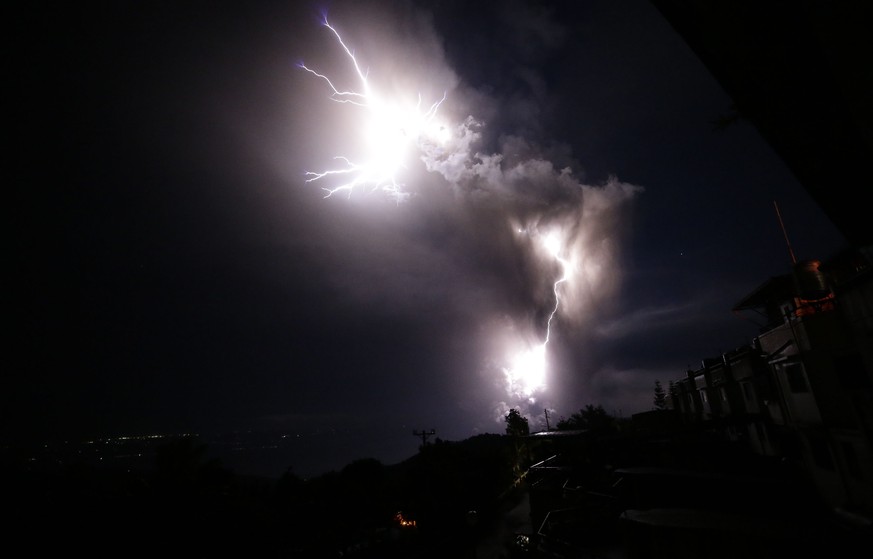 Lightning strikes beside the ash cloud as Taal Volcano erupts Sunday Jan. 12, 2020, in Tagaytay, Cavite province, outside Manila, Philippines. A tiny volcano near the Philippine capital that draws man ...