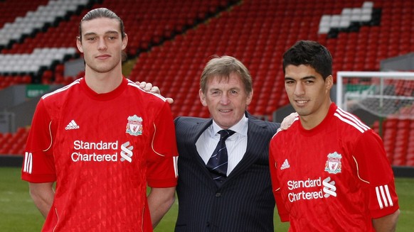 Liverpool manager Kenny Dalglish, center, poses for photos with new signings Andy Carroll, left, and Luis Suarez before a press conference at Anfield, Liverpool, England, Thursday Feb. 3, 2011. (AP Ph ...