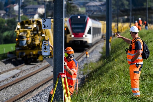 Des ouvriers travaillent a cote de la machine &quot;Puscal&quot; de l&#039;entreprise Scheuchzer lors d&#039;une visite de presse sur le chantier d&#039;entretien des voies CFF de 7km de long entre Pu ...