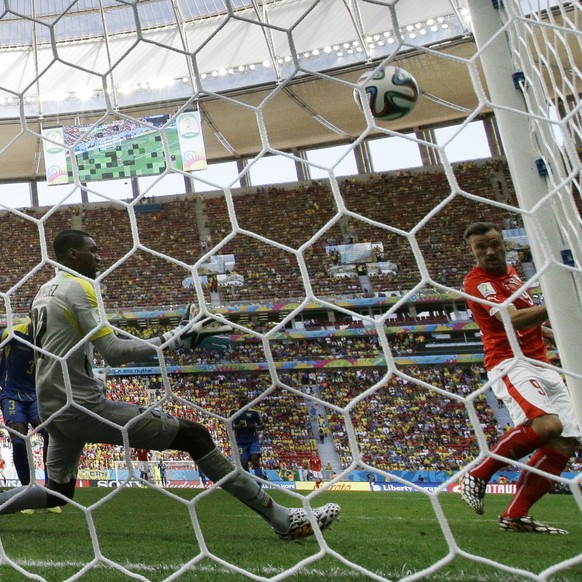 Switzerland&#039;s Haris Seferovic, right, scores his side&#039;s second goal past Ecuador&#039;s goalkeeper Alexander Dominguez during the group E World Cup soccer match between Switzerland and Ecuad ...