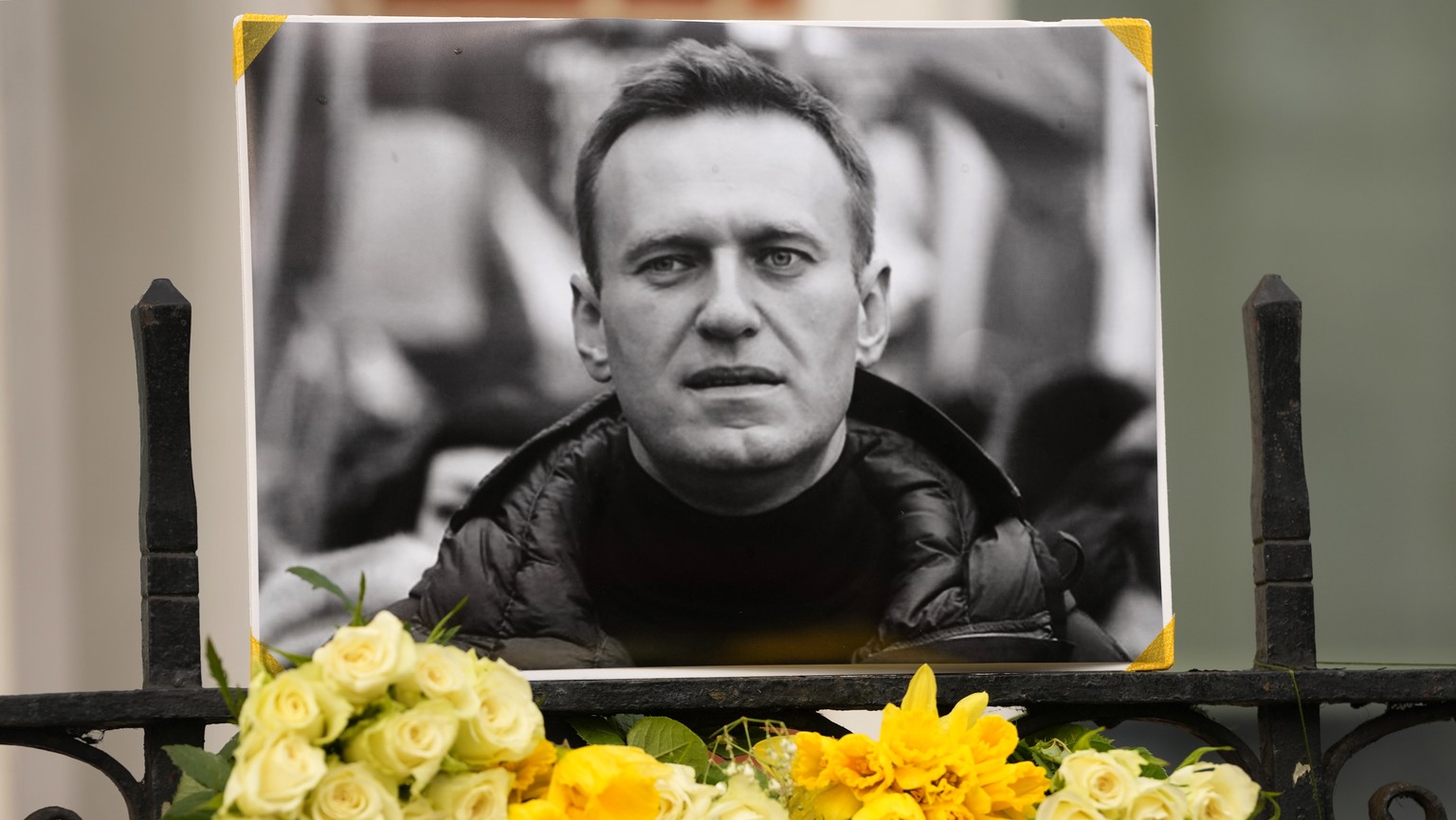 Flowers and a picture are left as a tribute to Russian politician Alexi Navalny, near to the Russian Embassy in London, Sunday, Feb. 18, 2024. Navalny, who crusaded against Russian corruption and stag ...