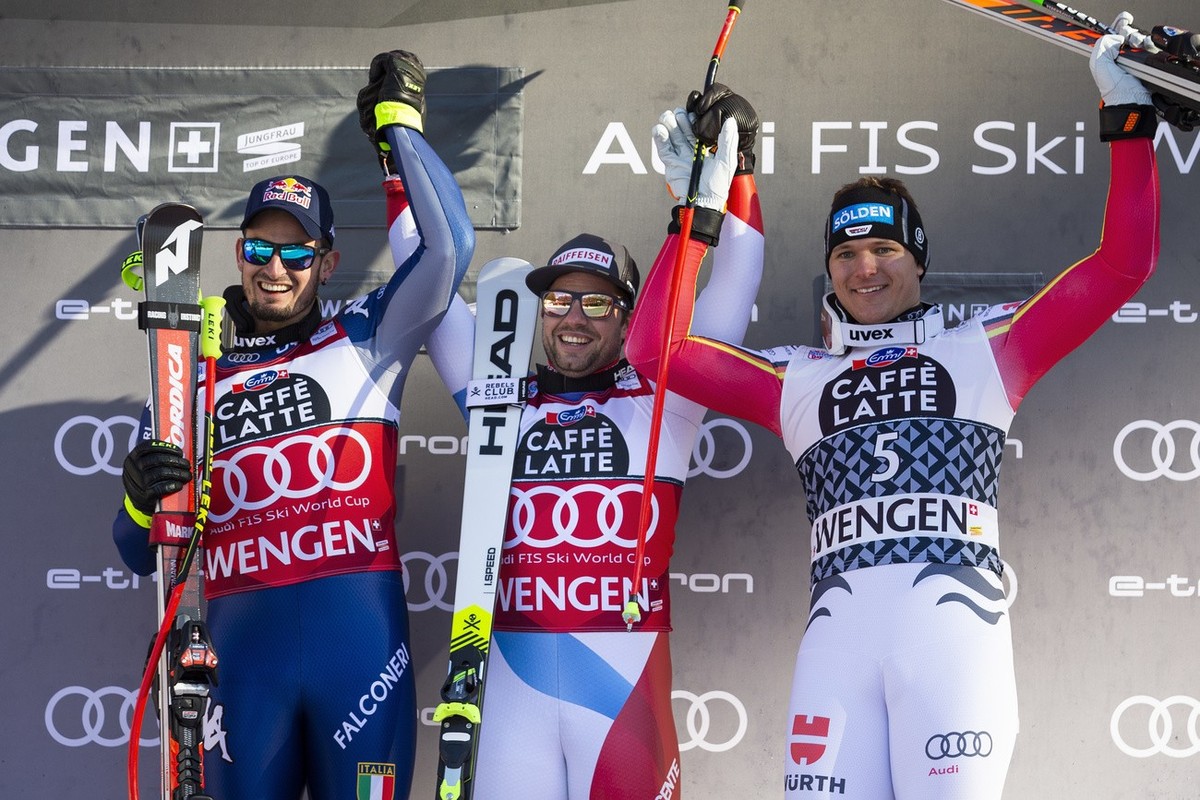 Dominik Paris of Italy (2nd place), Beat Feuz of Switzerland (winner) and Thomas Dressen of Germany (3rd place), from left, celebrate on the podium after the men's downhill race at the Alpine Ski ...