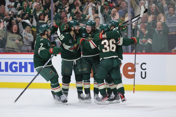 Minnesota Wild defenseman Quinn Hughes, second from the left, celebrates with teammates after scoring during the third period of Game 6 in the first round of the NHL hockey Stanley Cup playoff series  ...