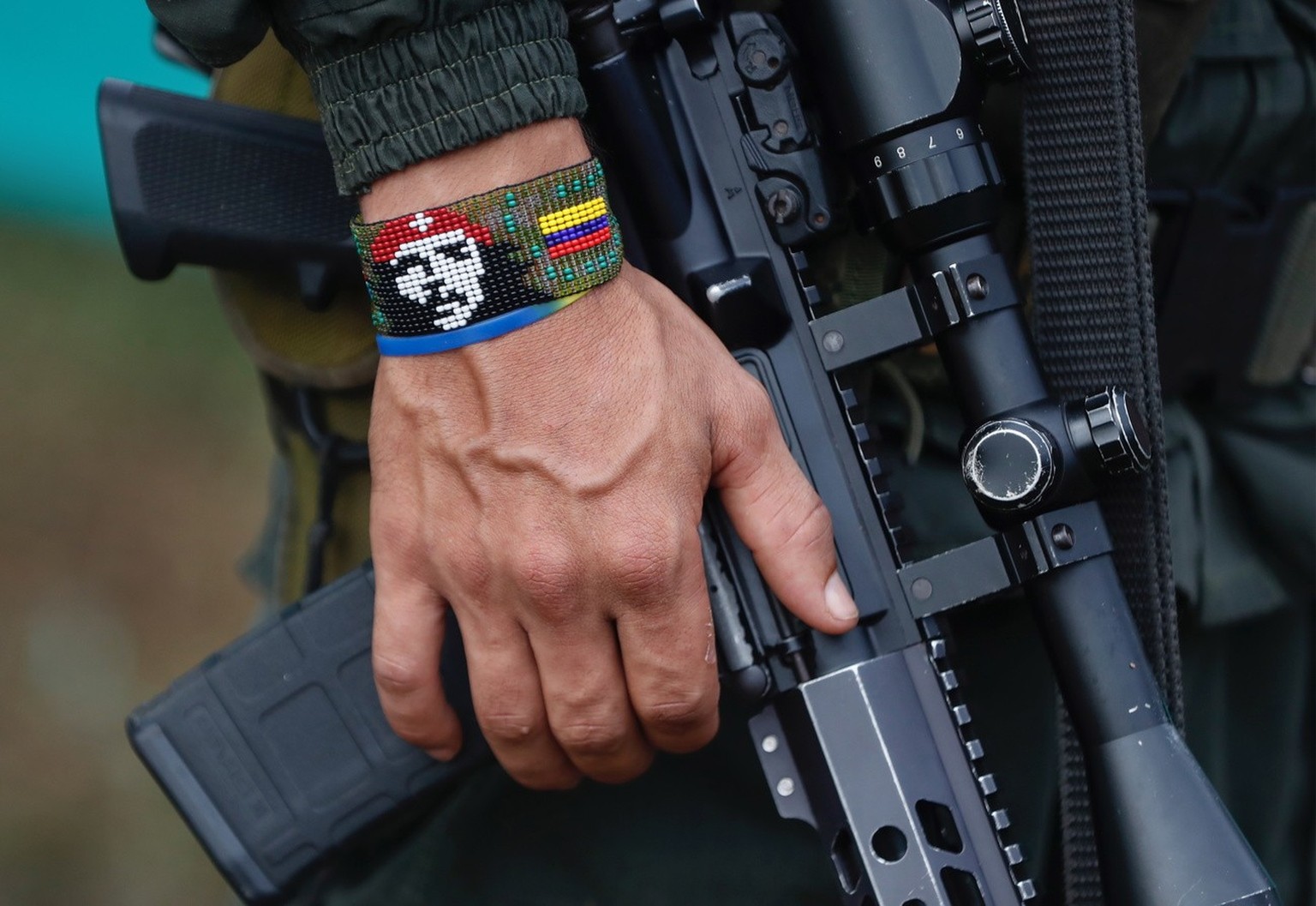 epa10577531 View of the handband of a FARC dissident guerrilla holding a rifle, in Casa Roja, Colombia, 16 April 2023 (issued 17 April 2023). Some 10,000 people were expected, and although the figure  ...