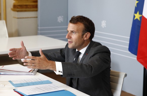 epaselect epa08390718 French President Emmanuel Macron speaks with Executive Presidents, mayors, associations and State representatives about the coronavirus outbreak during a video conference at the  ...