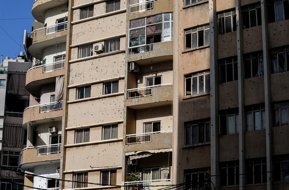 epa09523665 A view of a damaged building at the area of clashes in the Tayouneh neighborhood, southern suburb of Beirut, Lebanon, 14 October 2021. At least six people were killed and 20 wounded at a B ...