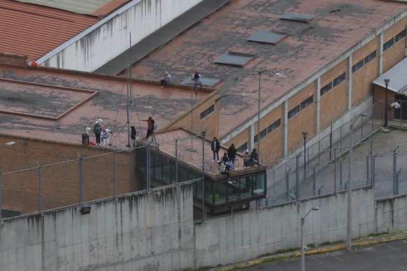 Prisoners stand on the roof of the Turi jail where dozens of prison guards and police officers have been kidnapped by the inmates, in Cuenca, Ecuador, Thursday, Aug. 31, 2023. In the last 24 hours, Ec ...