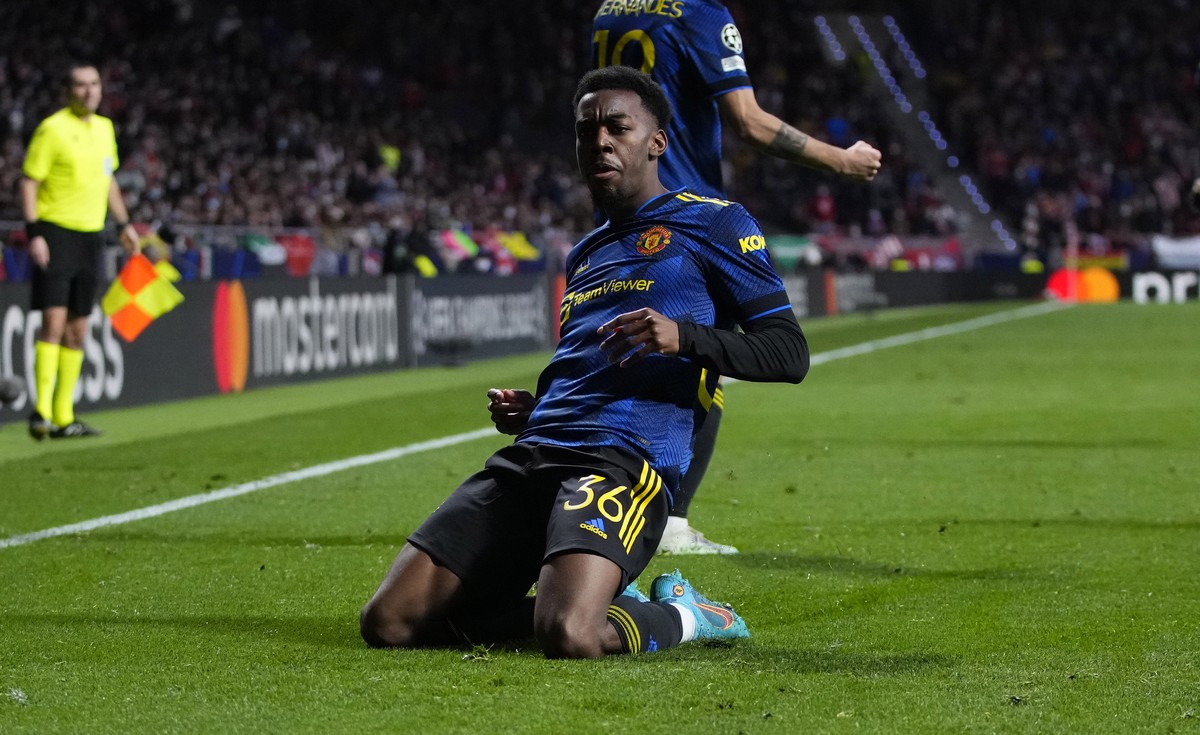 Manchester United's Anthony Elanga, bottom, celebrates after scoring his side's first goal during the Champions League, round of 16, first leg soccer match between Atletico Madrid and Manche ...