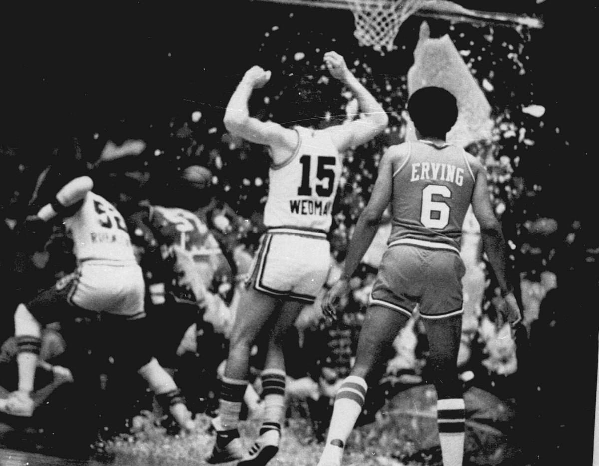FILE - This Nov. 1979, file photo shows Kansas City Kings' Scott Wedman and Philadelphia 76ers' Julius Erving watching as Kings' Bill Robinzine, left, and 76ers' Darryl Dawkins run ...