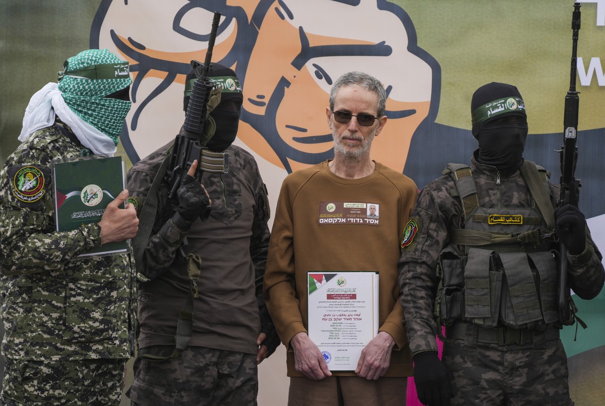 Israeli captive, Ohad Ben Ami, who has been held hostage by Hamas in Gaza since Oct. 7, 2023, is escorted by Hamas fighters before being handed over to the Red Cross in Deir al-Balah, central Gaza Str ...