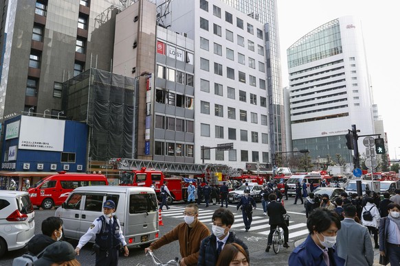 Fire engines park near a building, center in the background, where a fire broke out in Osaka, western Japan Friday, Dec. 17, 2021. Dozens of people are feared dead after a fire broke out in the buildi ...