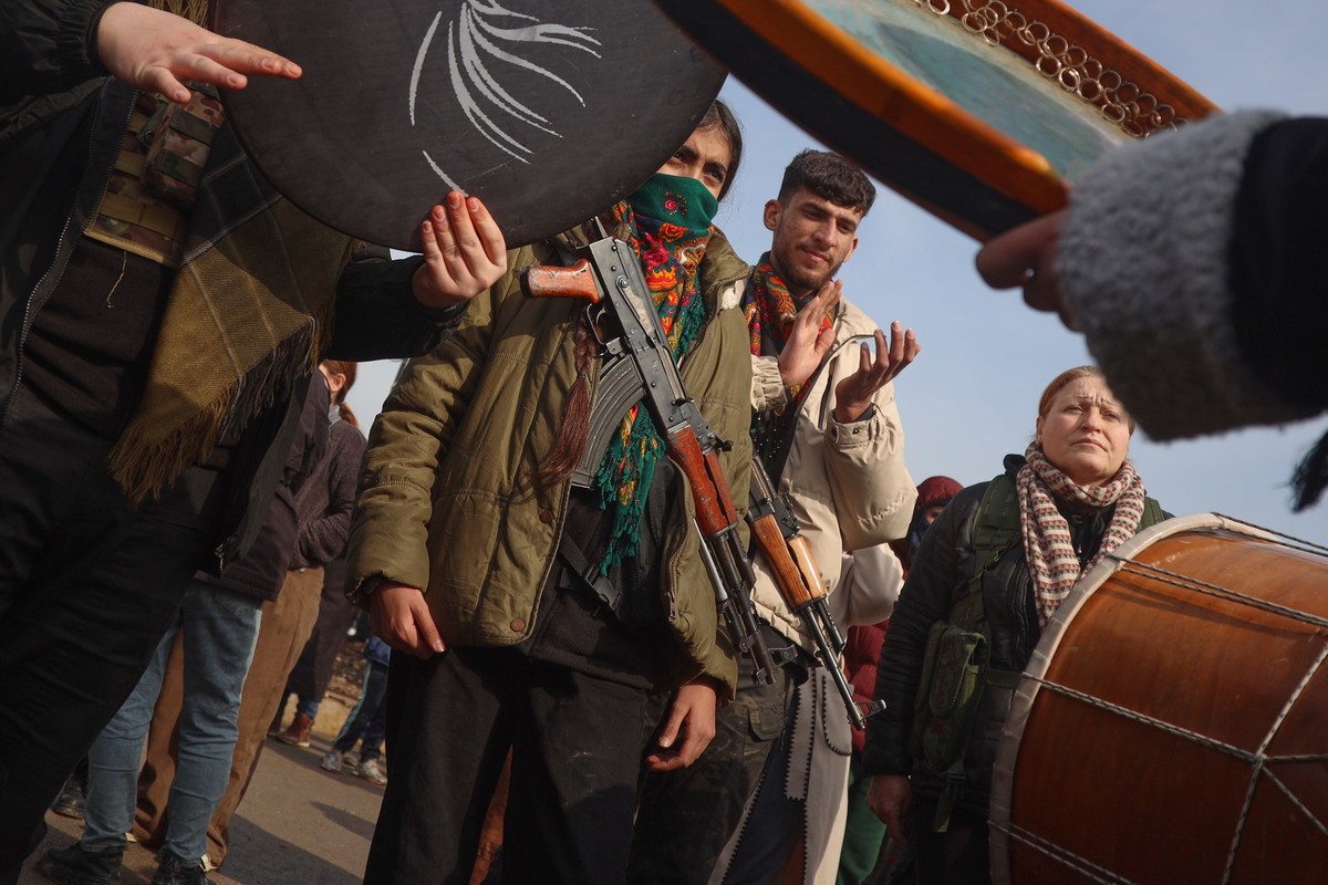 Kurdish fighters with the Syrian Democratic Forces (SDF) are cheered by local residents ahead of the end of a four-day truce with the Syrian government in Hassakeh, northeastern Syria, Saturday, Jan.  ...