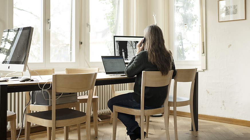 Eine Frau telefoniert an ihrem Arbeitsplatz im Homeoffice. Mit dem Homeoffice ergeben sich besondere Herausforderungen f