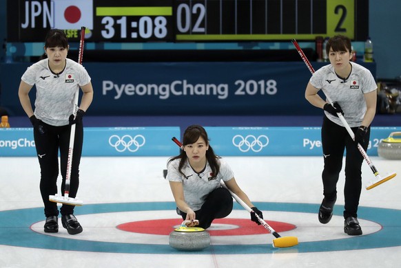 Japan's Chinami Yoshida, center, prepares to throw the stone during their women's curling match against Denmark at the 2018 Winter Olympics in Gangneung, South Korea, Thursday, Feb. 15, 2018. (AP Photo/Aaron Favila)