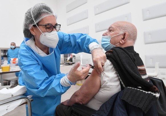 epa09095736 An enderly person is given a dose of the Covid-19 vaccine by a healthcare personnel at a vaccination center in Binasco, near Milan, Italy, 25 March 2021 EPA/DANIEL DAL ZENNARO