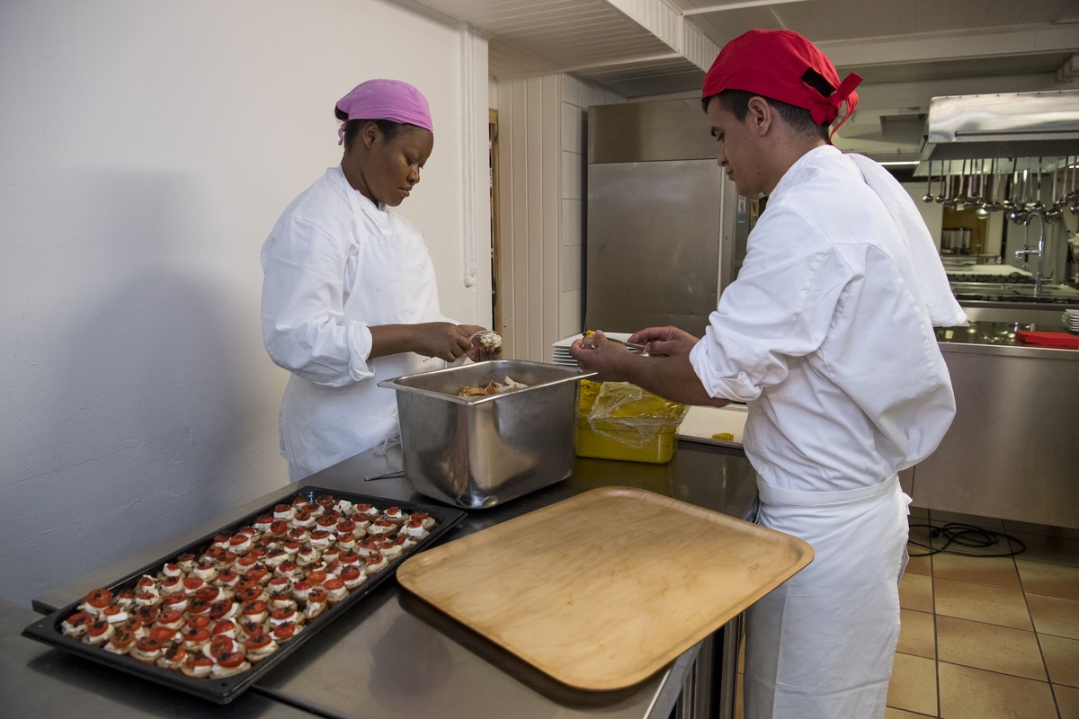 Des requerants d'asile aident en cuisine lors d'une conference de presse avant la reouverture du restaurant "Le temps de vivre" ce mardi 26 juillet 2016 aux Mayens-de-Chamoson en V ...