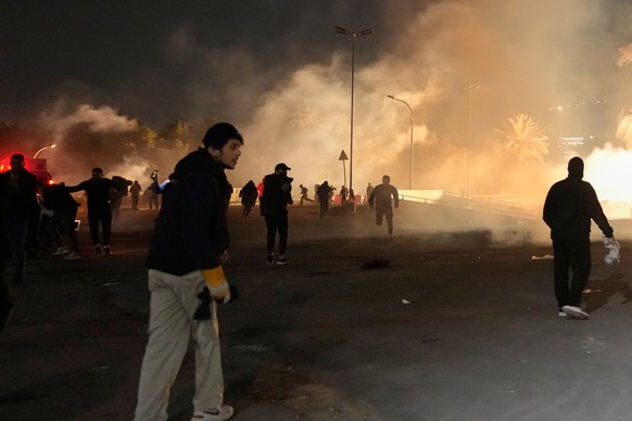 Security forces fire tear gas to disperse a protest against U.S. and Israeli attacks on Iran, at a bridge leading to the fortified Green Zone where the U.S. Embassy is located, in Baghdad, Iraq, Monda ...