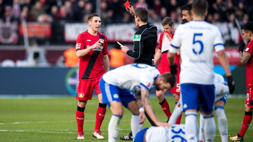 25.02.2018, Nordrhein-Westfalen, Leverkusen: Fussball: Bundesliga, 24. Spieltag, Bayer Leverkusen - FC Schalke 04 in der BayArena. Schiedsrichter Daniel Siebert zeigt Leverkusens Dominik Kohr (l) die  ...