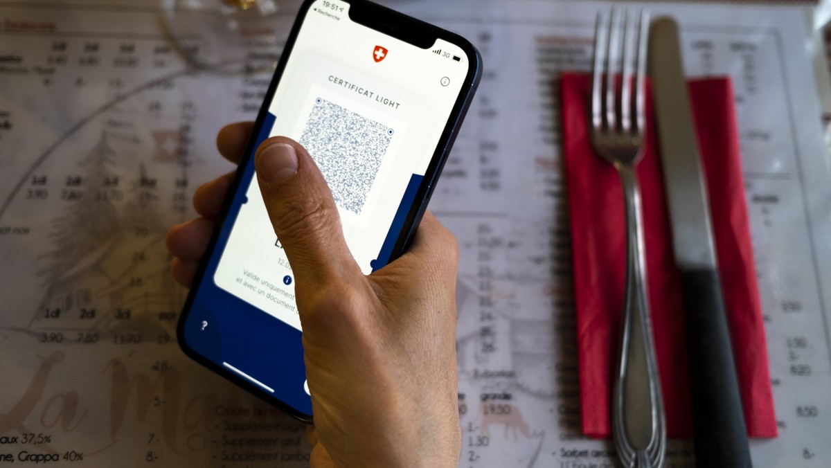 Une personne tient dans sa main un smartphone avec l'application Certifact Covid suisse et un certificat light dans un restaurant ce vendredi 10 septembre 2021 a Rances dans le canton de Vaud. De ...