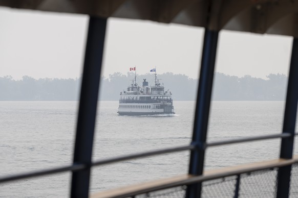 epa13116025 A ferry carrying tourists crosses a hazy Lake Ontario towards Toronto Island, Toronto, Ontario, Canada, 16 July 2026. Toronto has been ranked among the worst major cities in the world for  ...