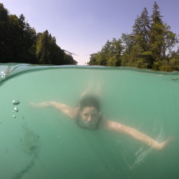 A woman swimms in the Aare River between Thun and Bern, Switzerland, during the sunny and warm weather, Sunday, June 30, 2019. The forecast predicts hot weather in Switzerland with maximum temperature ...