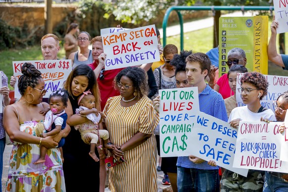 epa10030348 Parents and children hold signs as the group calls on Republican Georgia Governor Brian Kemp to return reported campaign contributions from Daniel Defense, the gun manufacturer of the AR-1 ...
