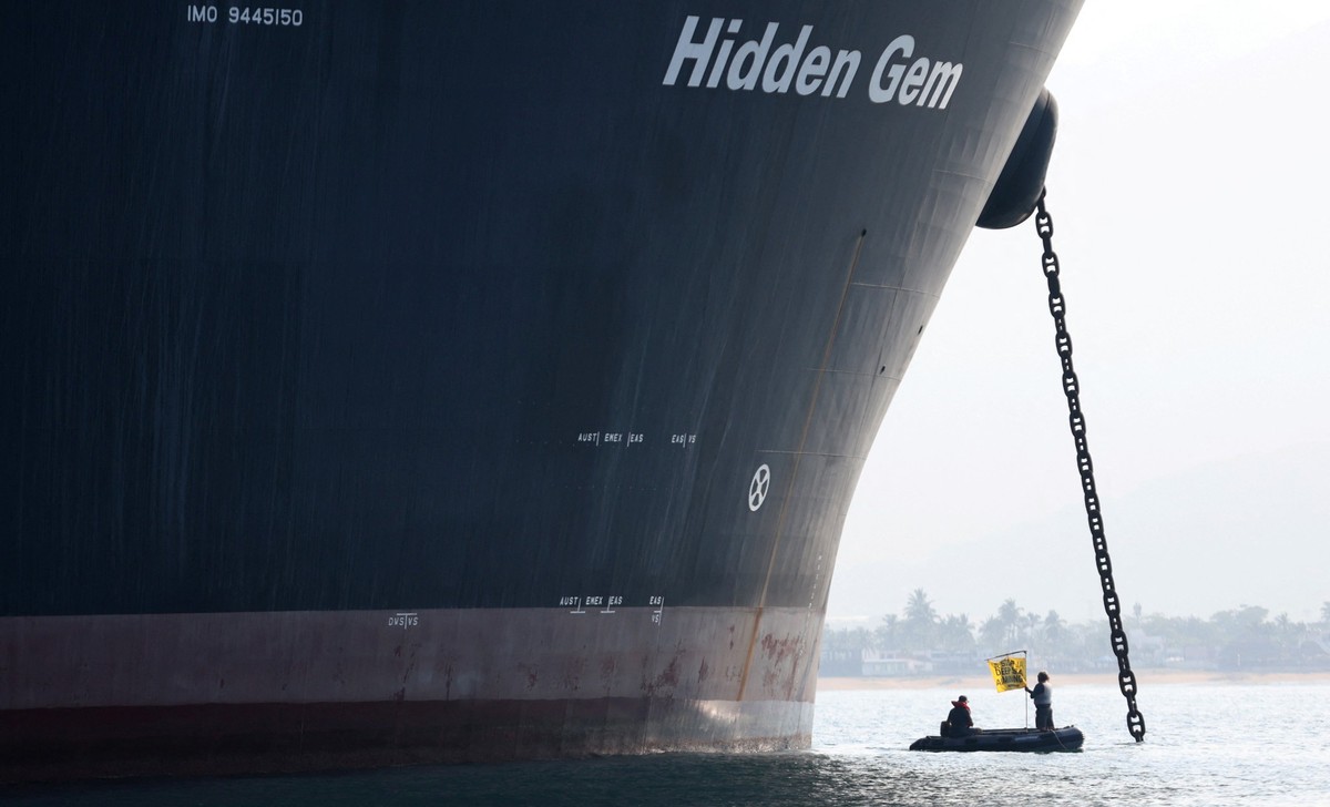 A Greenpeace activist holds a banner during a protest near the deep sea mining vessel Hidden Gem, commissioned by Canadian miner The Metals Company, in the Mexican Pacific port of Manzanillo, in Manza ...