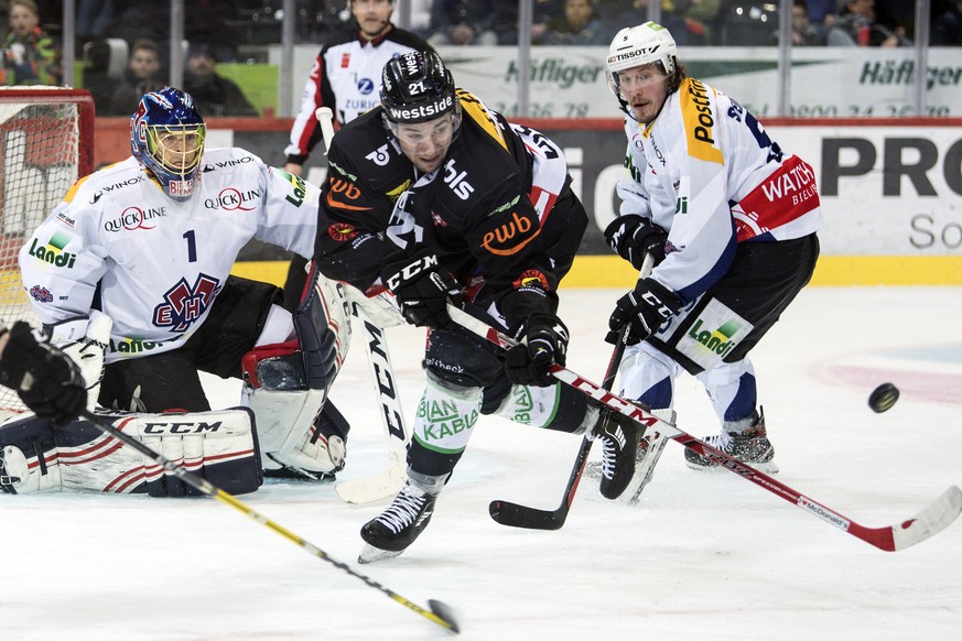 Berns Simon Moser, Mitte, im Duell mit Goalie Jonas Hiller, links, Nicholas Steiner im ersten Eishockey Playoff-Viertelfinalspiel der National League A zwischen dem SC Bern und dem EHC Biel am Samstag ...