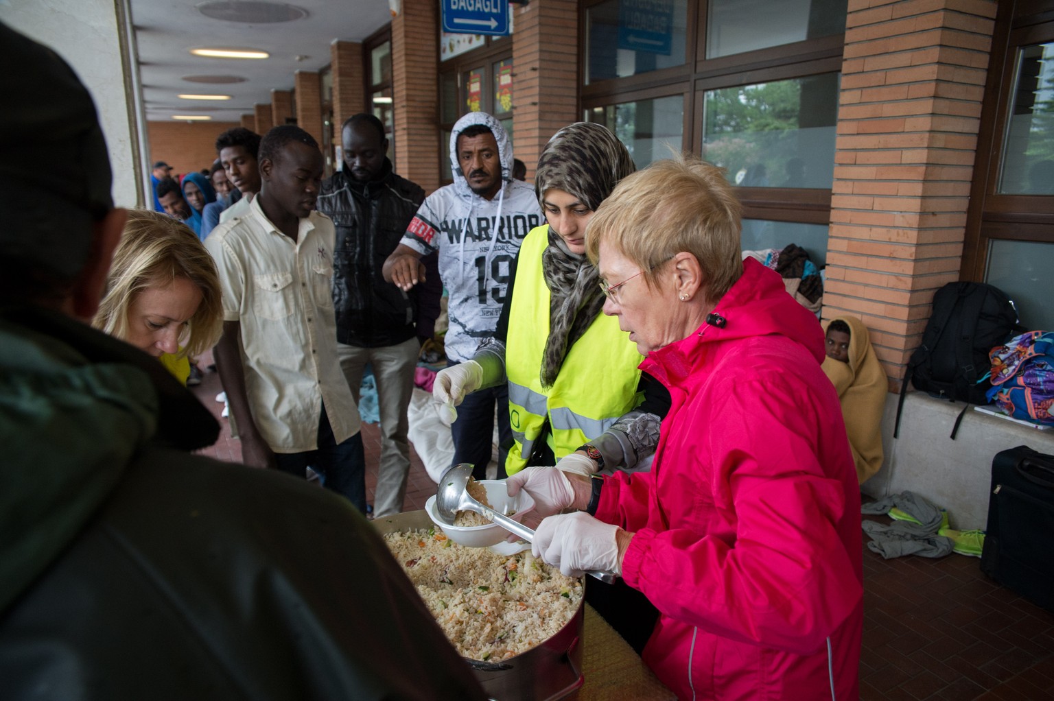 Freiwillige Helfer aus dem Tessin verteilen in Como Essen an die abgewiesenen Flüchtlinge.
