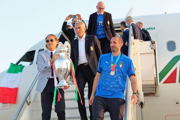 epa09339554 Italy captain Giorgio Chiellini (R) and head coach Roberto Mancini (L) show the European Championship trophy as the Italian football team returns from London after winning the UEFA EURO 20 ...