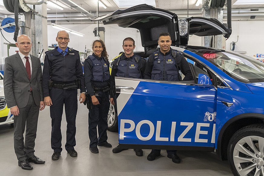 Regierungsrat Baschi Duerr, der Kommandant der Kantonspolizei Martin Roth, und die Polizisten Dorothea Allotey, Cyril Riebli und Adrian Spahr, von links, vor einem Tesla X 100D, als Bestandteil der er ...