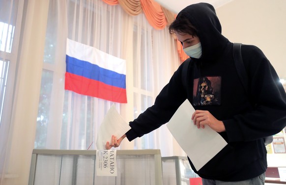 epa09476747 A man votes in a polling station at a local school during the Parliamentary elections in Podolsk outside Moscow, Russia, 19 September 2021. Elections of deputies of the State Duma, governo ...