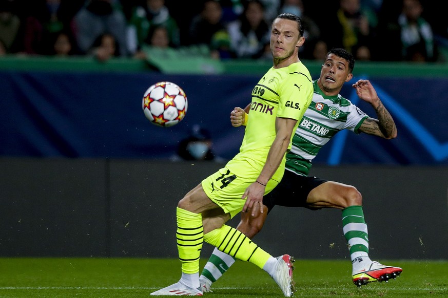 epa09601636 Sporting player Pedro Porro (R) fights for the ball with Borussia Dortmund player Nico Schulz during the UEFA Champions League Group C soccer match at Alvalade Stadium in Lisbon, Portugal, ...