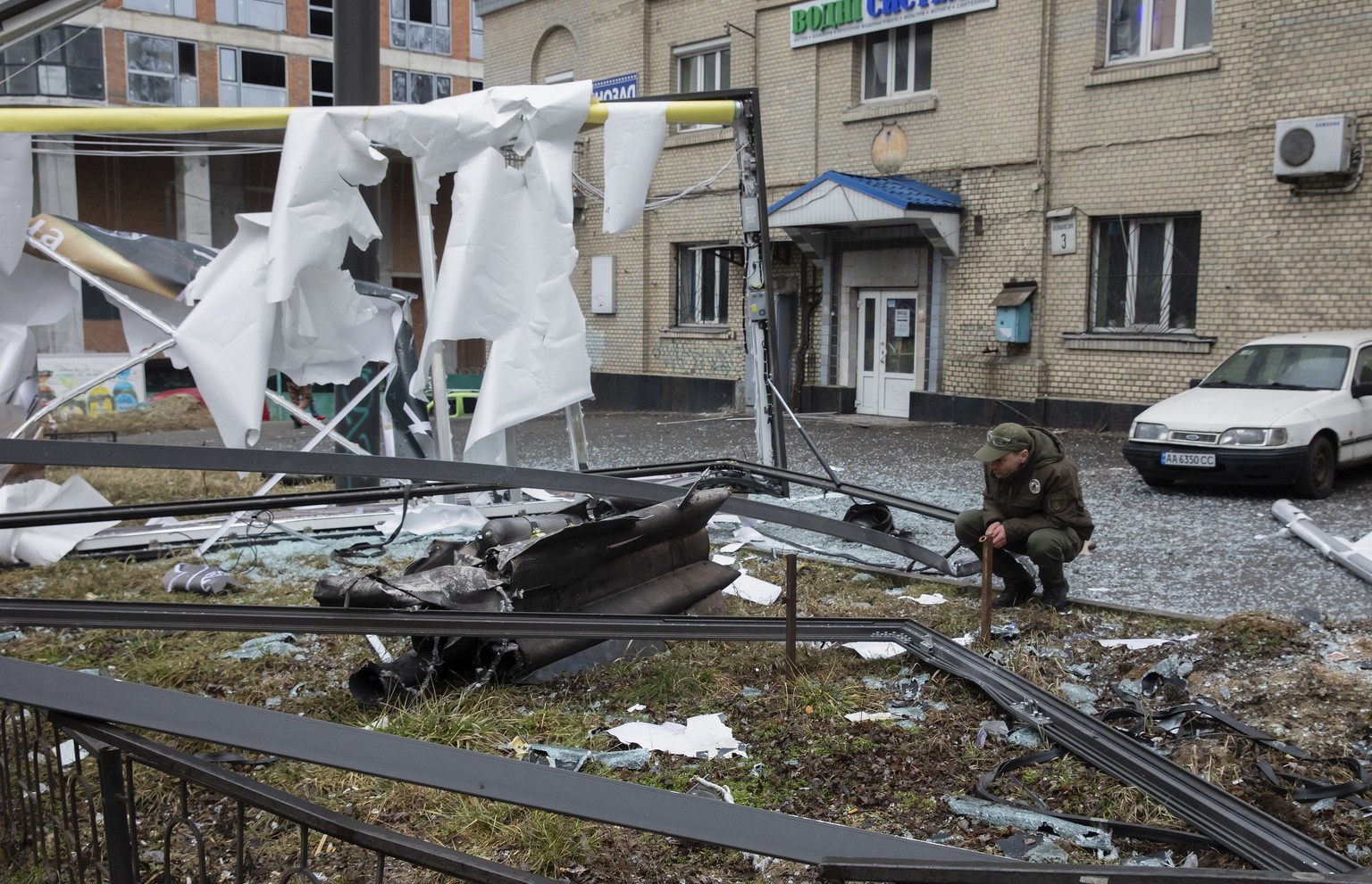 epaselect epa09780184 A man looks at the debris of an unidentified object in the aftermath of an explosion in Kiev, Ukraine, 24 February 2022. The Russian president authorized a special military opera ...