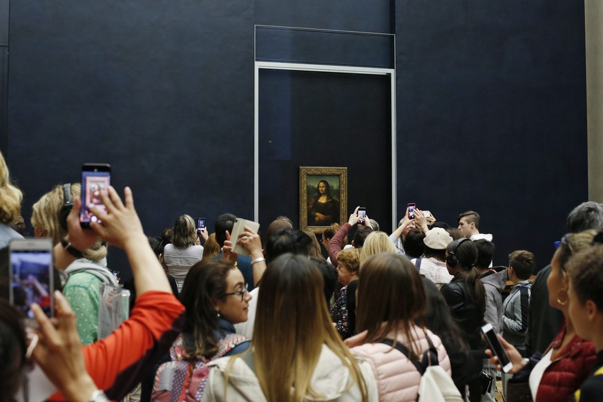 Tourists wait to see Leonardo da Vinci&#039;s painting Mona Lisa, at the Louvre museum, in Paris, Wednesday, Oct. 23, 2019. The Louvre, the home of the &quot;Mona Lisa,&quot; is commemorating the 500t ...