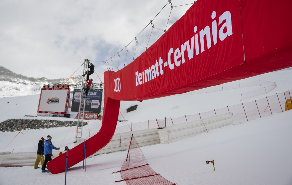 Volunteers mount the finish gate, ahead of the women's downhill race on the new ski course "Gran Becca" at the Alpine Skiing FIS Ski World Cup Zermatt-Cervinia, in Cervinia, Italy, Sund ...