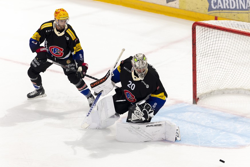 PostFinance Top Scorer Fribourg's defender Ryan Gunderson, left, and Fribourg's goaltender Reto Berra, right, look the puck, during the game of National League A (NLA) Swiss Championship between HC Fr ...