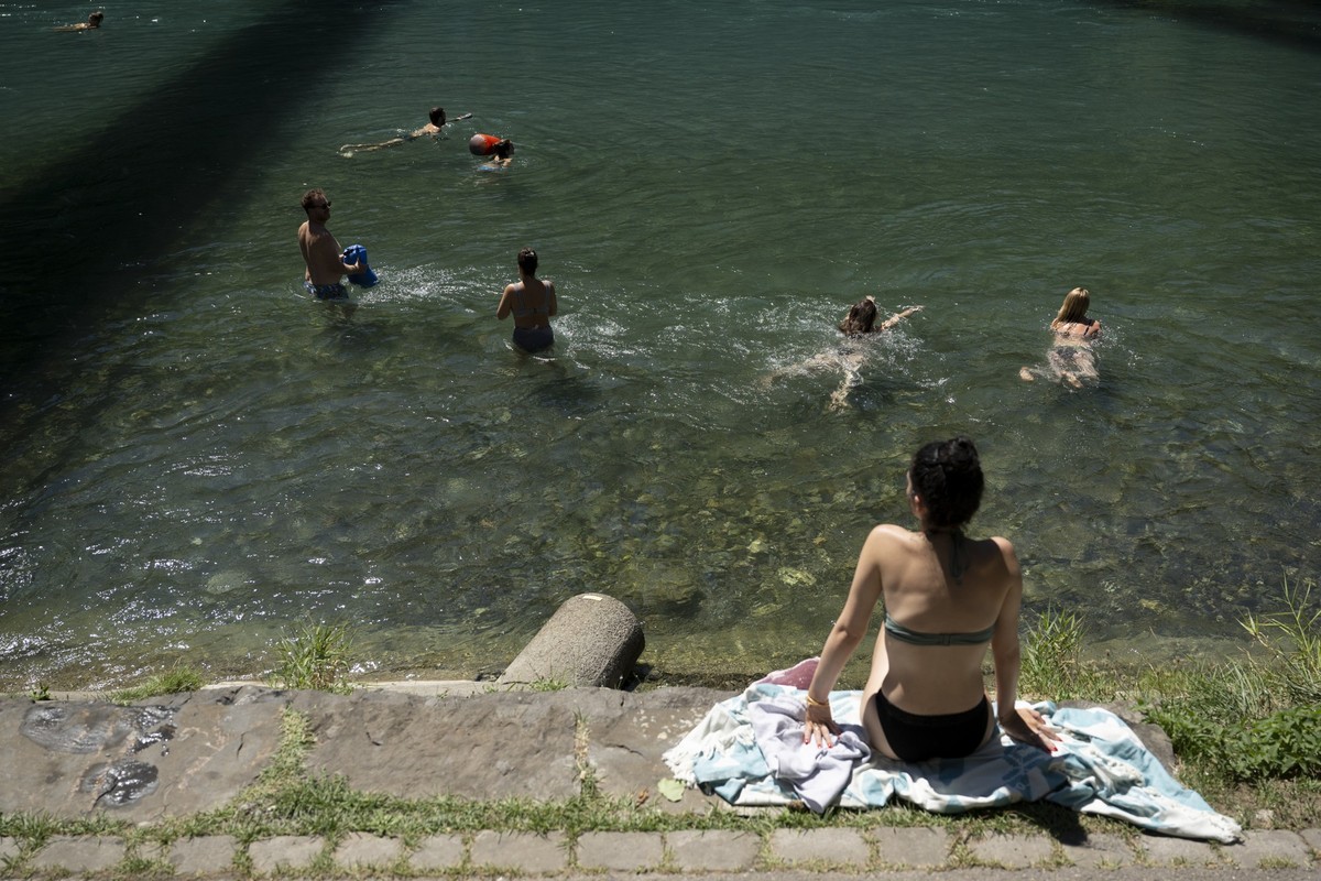 Menschen tauchen in die Aare, am Mittwoch, 3. August 2022, in Bern. Seit Beginn des Sommers wird die Schweiz von starken Hitzewellen und Duerreperioden heimgesucht. (KEYSTONE/Anthony Anex)