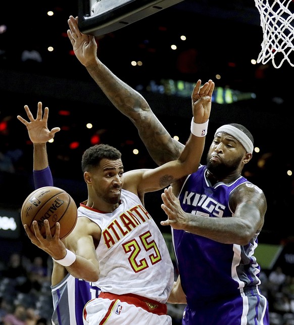 Atlanta Hawks' Thabo Sefolosha (25) of Switzerland, puts up a shot against the defense of Sacramento Kings' Garrett Temple, rear, and DeMarcus Cousins, right, in the second quarter of an NBA ...