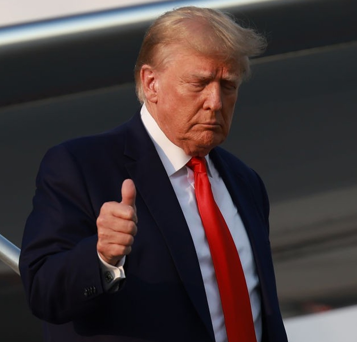 ATLANTA, GEORGIA - AUGUST 24: Former U.S. President Donald Trump gives a thumbs up as he arrives at Atlanta Hartsfield-Jackson International Airport on August 24, 2023 in Atlanta, Georgia. Trump is ex ...