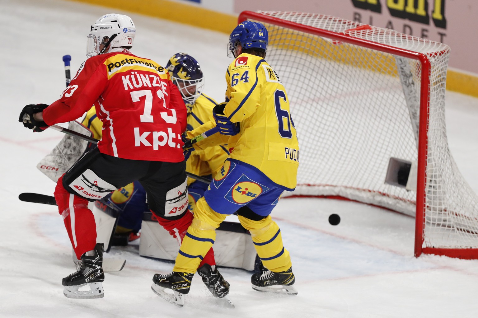 epa09931655 Switzerland&#039;s Janis Jarome Moser (not in picture) scoring his teams second goal Mike Kunzle (L) during the Beijer Hockey Games (Euro Hockey Tour) match between Sweden and Switzerland  ...