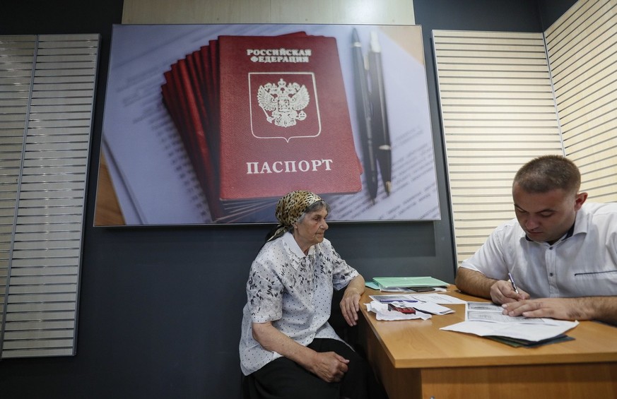 epa10149887 A picture taken during a visit to Berdyansk organized by the Russian military shows a resident submitting documents at a center for the preparation of documents for the registration of Rus ...